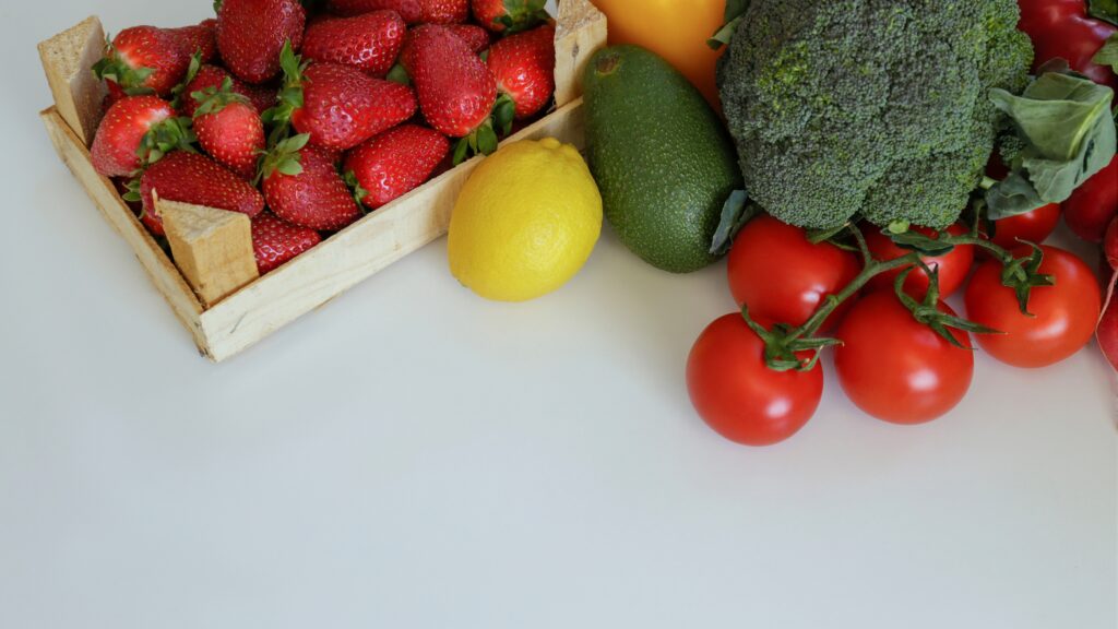 Des fruits et légumes frais comme des fraises, des tomates, des avocats, et du brocoli, éléments clés d'une alimentation végétale saine.