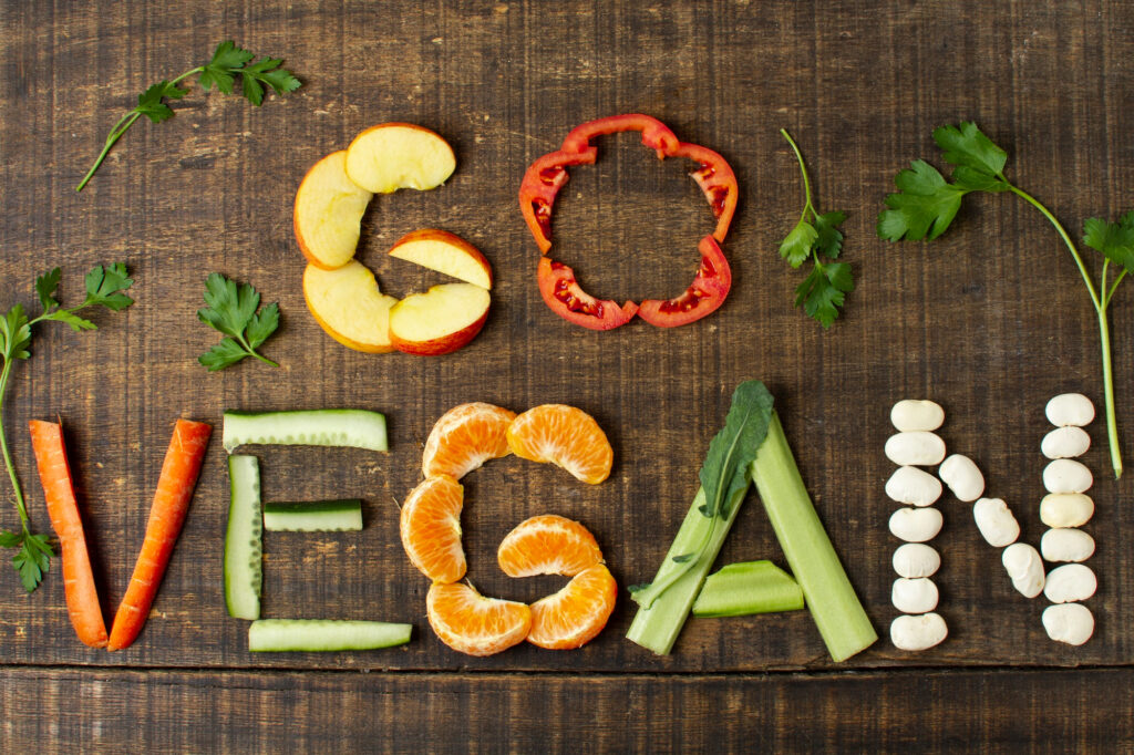 Lettres formant "Go Vegan" réalisées avec des fruits et légumes, représentant une alimentation saine pour une bonne santé.