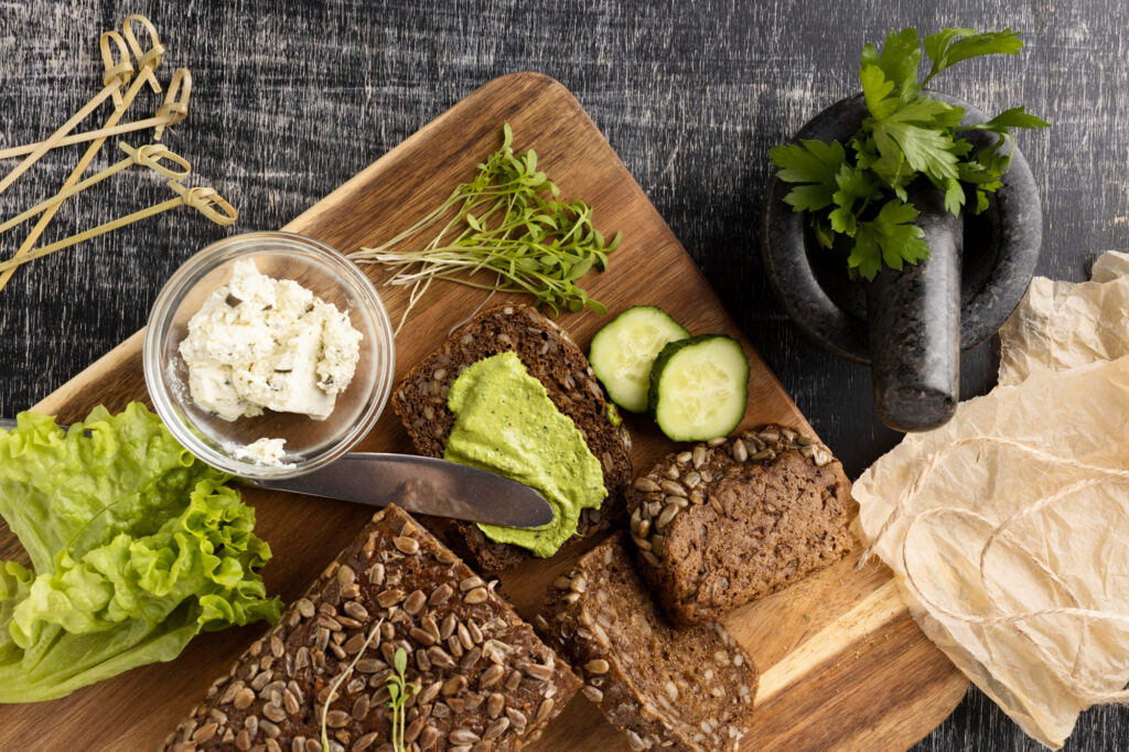 Pain complet avec des légumes verts, du fromage végétal et des pousses, idéal pour une bonne santé.