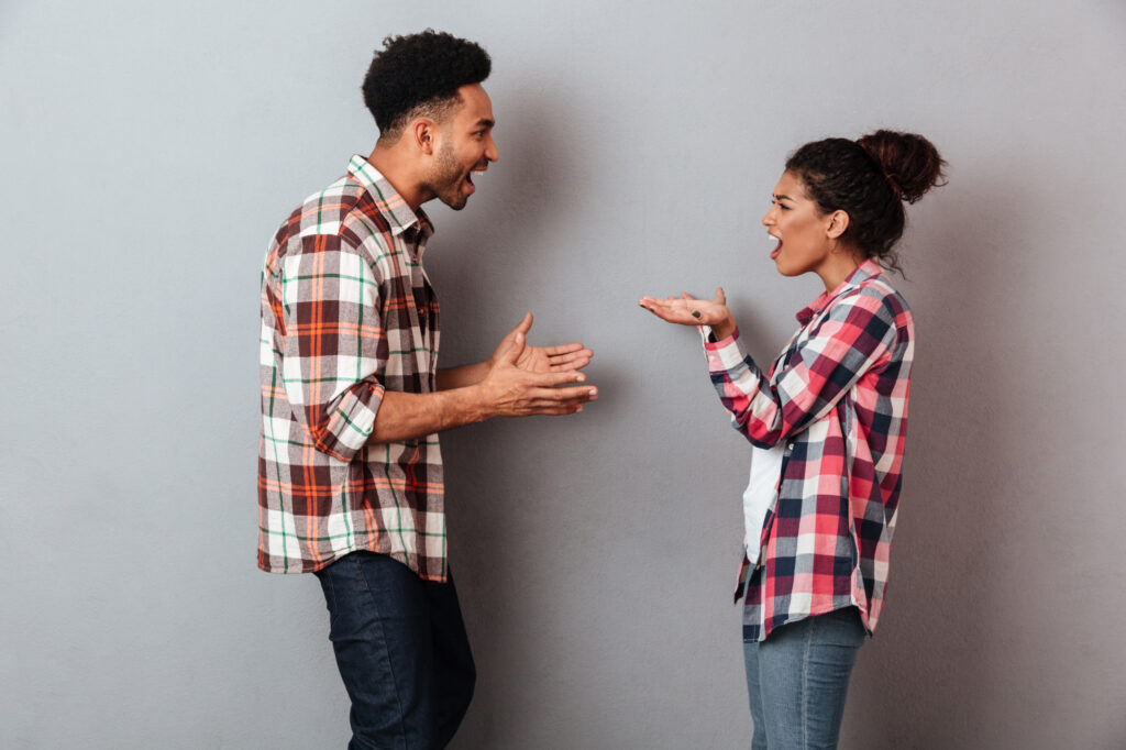 Un homme et une femme en pleine dispute, symbolisant les débats animés qui peuvent survenir lors de discussions sur les remarques anti-végétariennes.