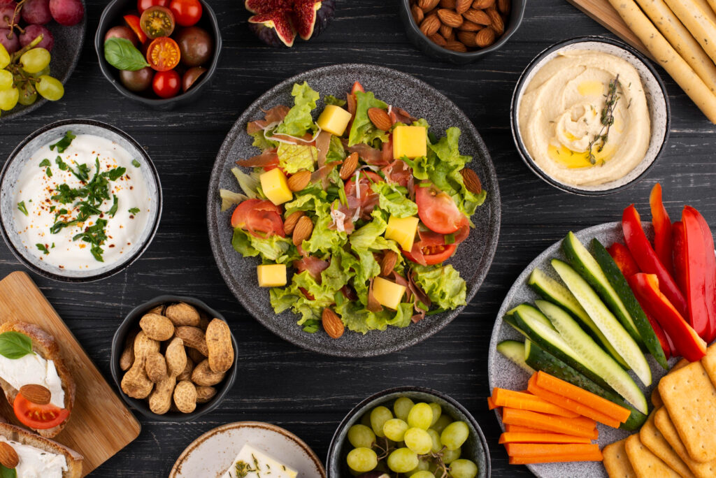 Un assortiment d'amandes, légumes frais, houmous et salade, un repas végétariens équilibrés complet et délicieux.