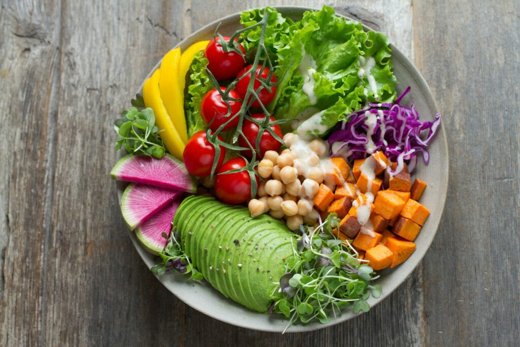 Bol de salade colorée avec avocat, pois chiches et légumes riches en protéines végétales.