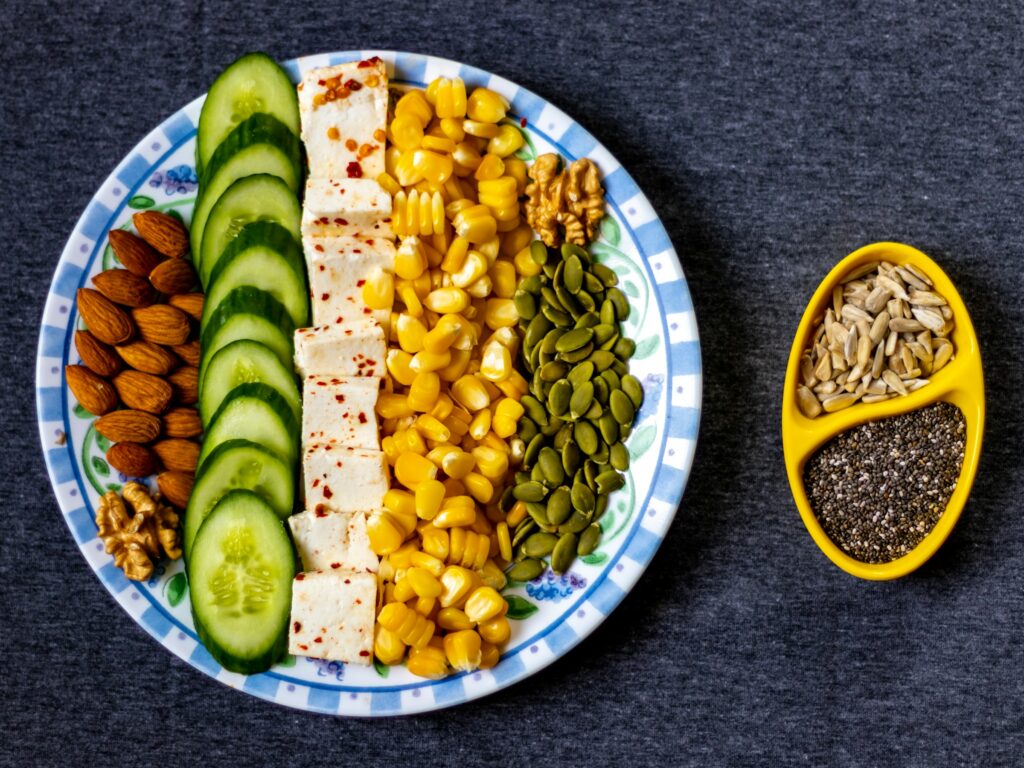 Assiette de légumes, tofu, graines et noix, remplie de protéines végétales.