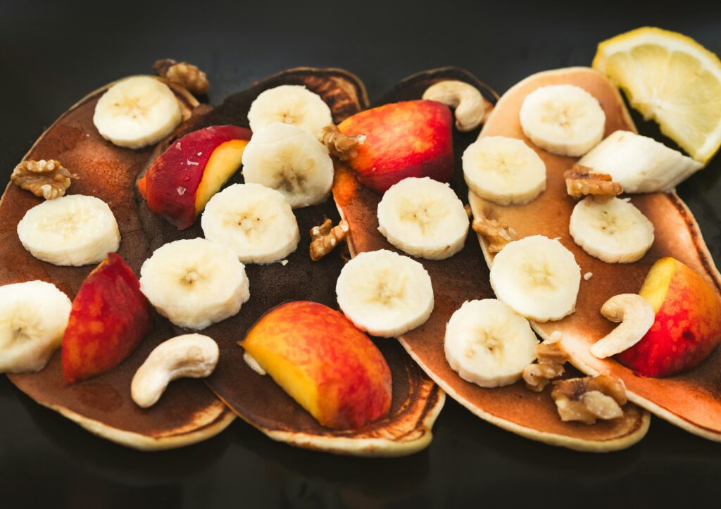 Pancakes véganes garnis de bananes, noix et pêches, parfaits pour le véganisme.